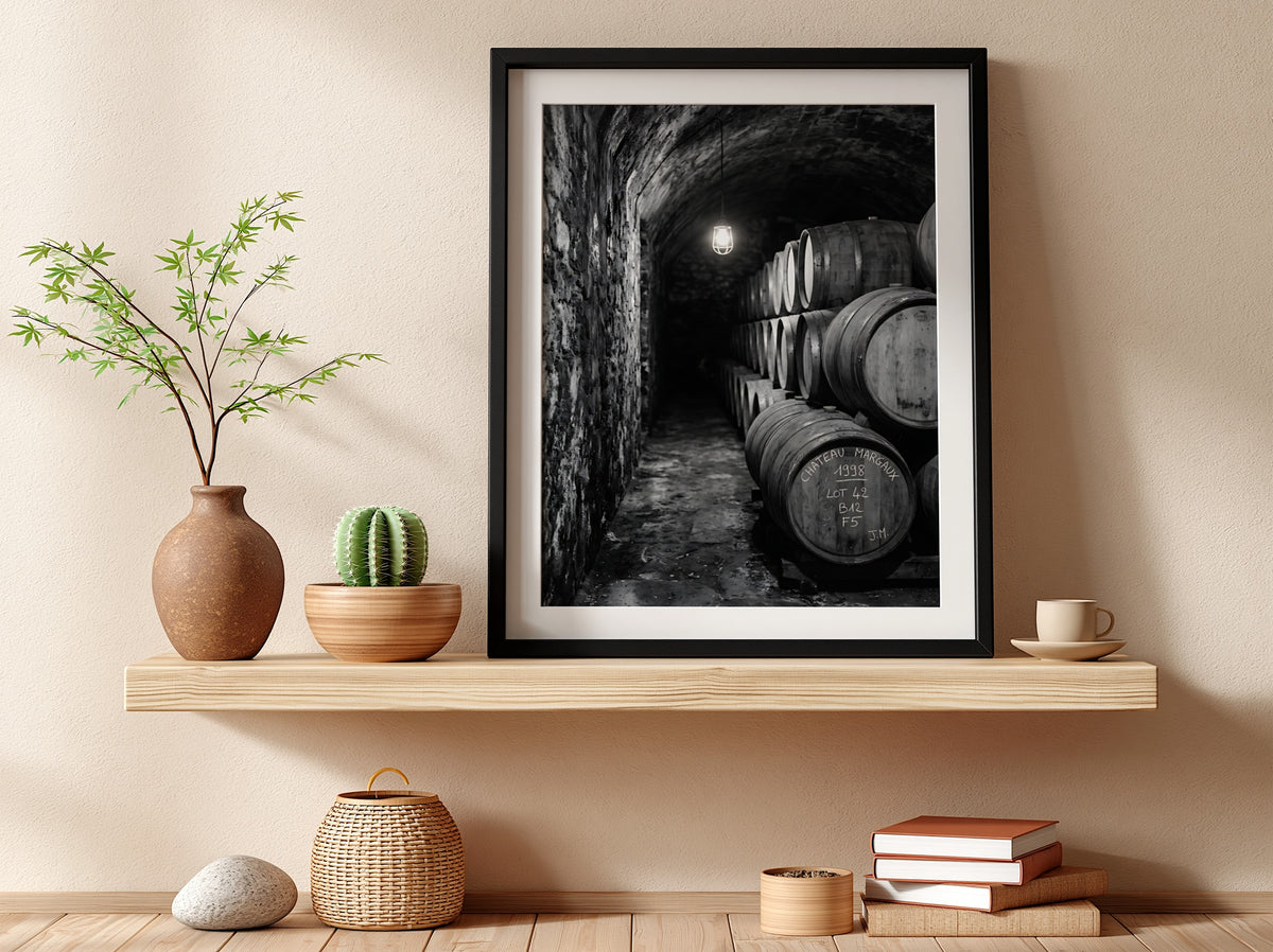 Wall decor featuring black and white photograph of oak wine barrels stacked in stone cellar under soft light