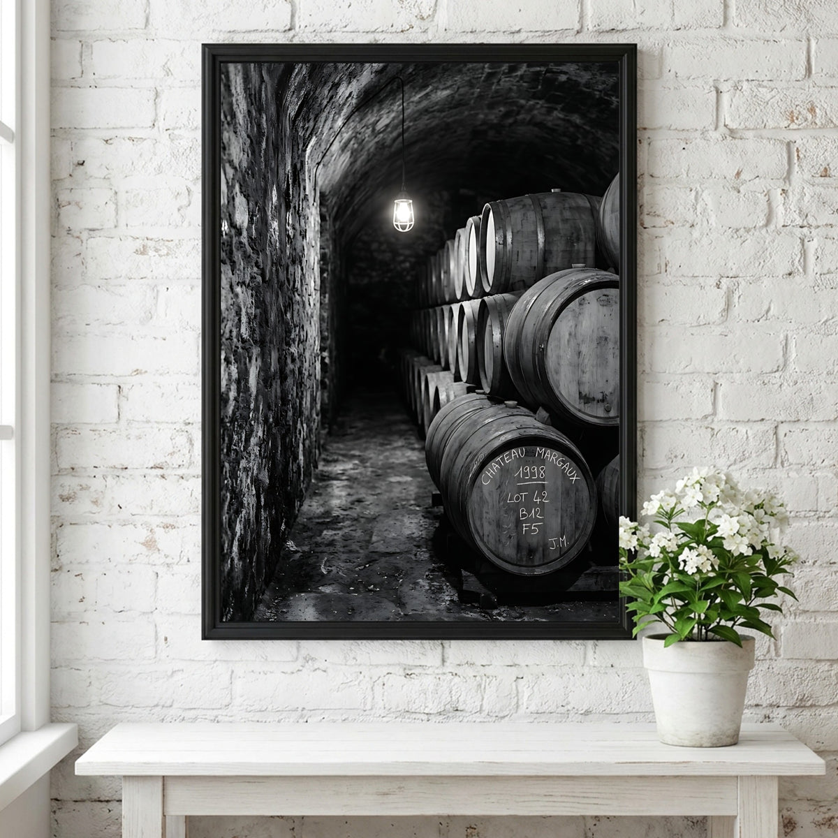 Wall decor featuring black and white photograph of oak wine barrels stacked in stone cellar under soft light