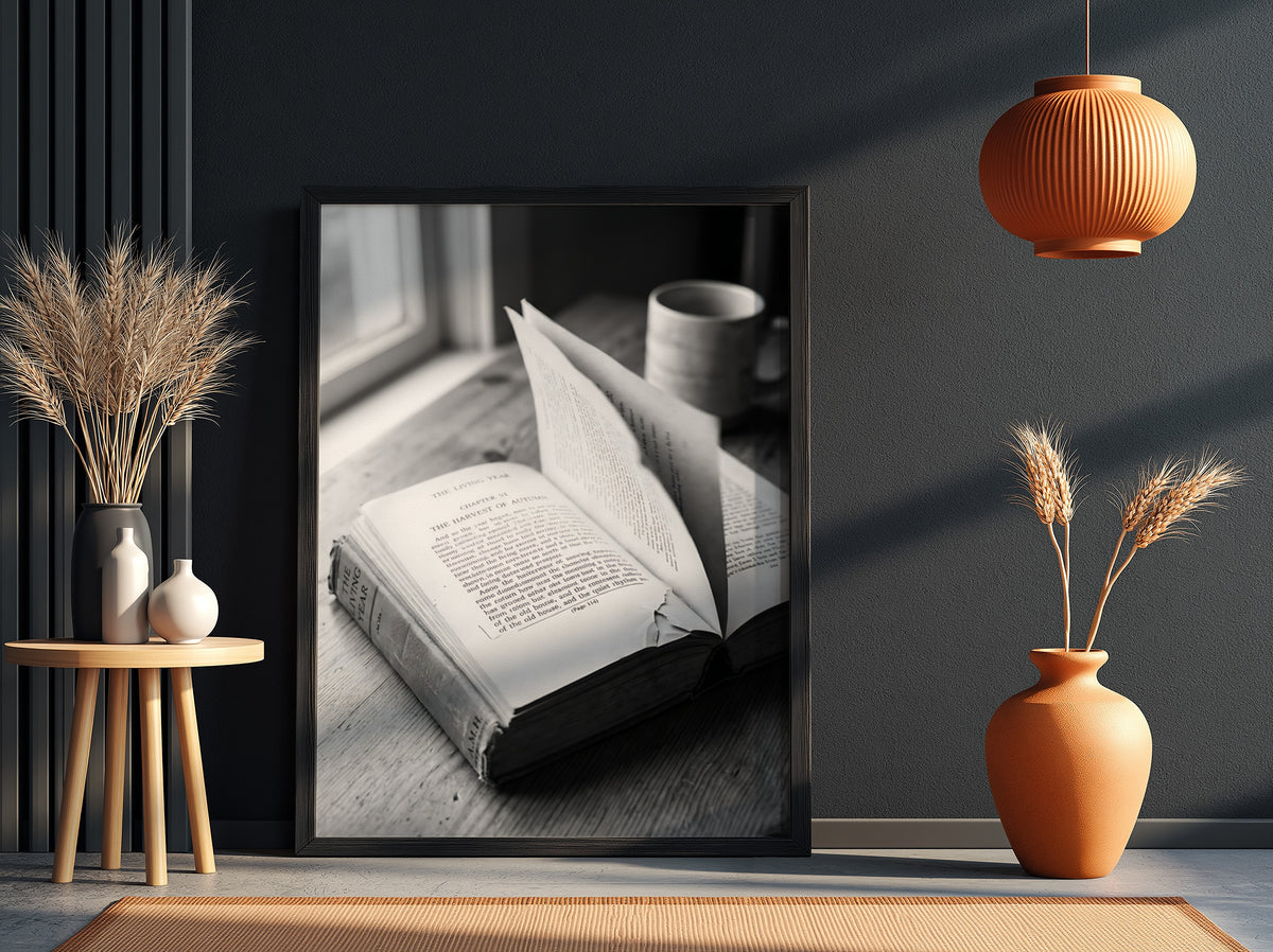 Black and white wall decor showing an open book with pages turning on a wooden surface with soft natural light