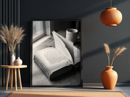 Black and white wall decor showing an open book with pages turning on a wooden surface with soft natural light