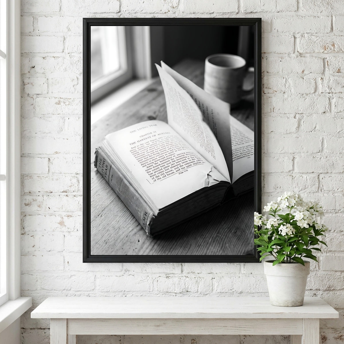 Black and white wall decor showing an open book with pages turning on a wooden surface with soft natural light