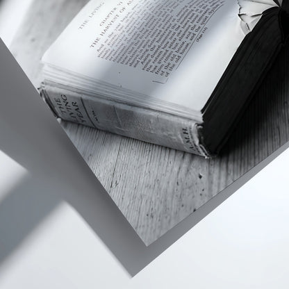 Black and white wall decor showing an open book with pages turning on a wooden surface with soft natural light