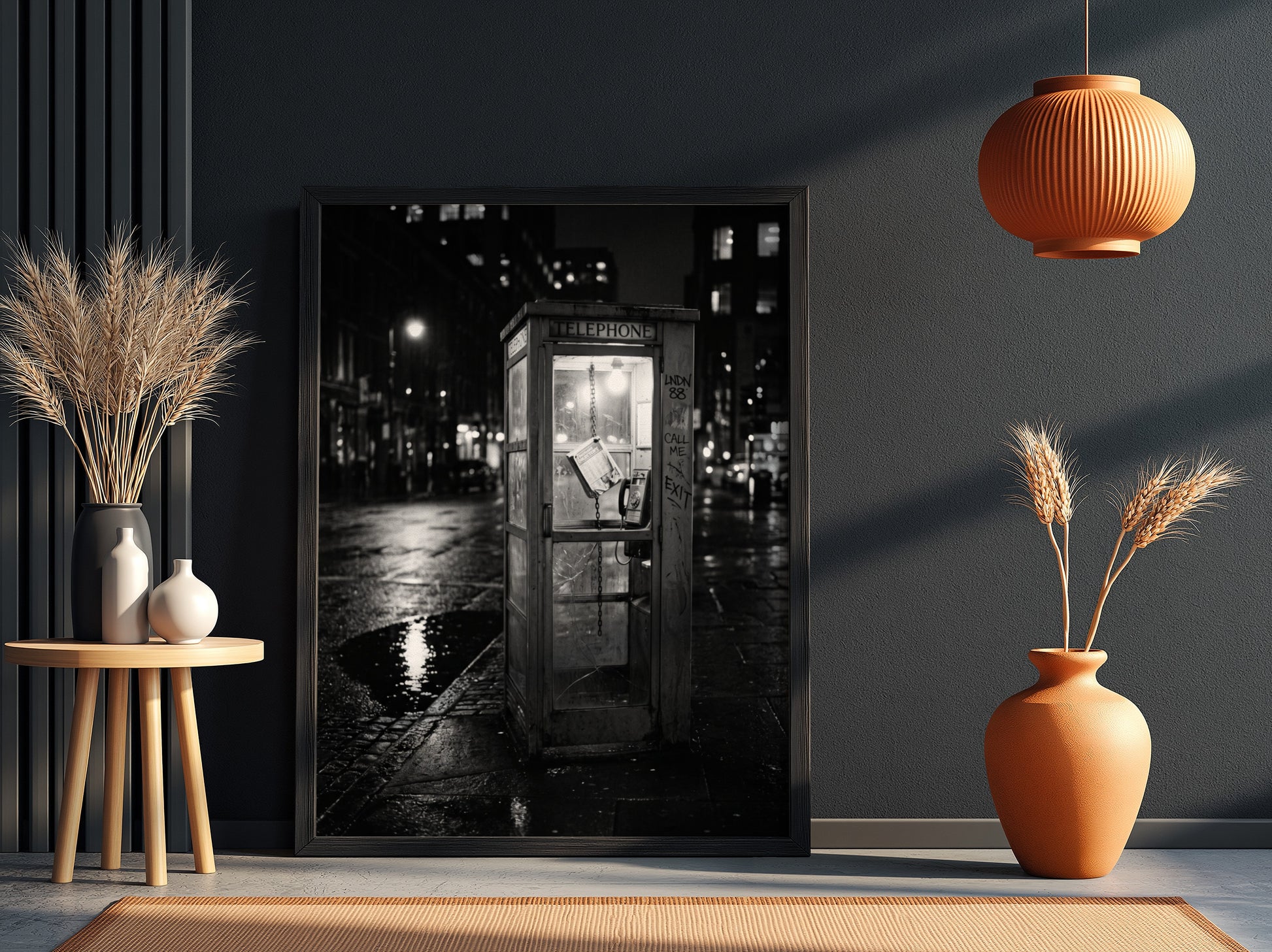 black and white wall decor of illuminated phone booth on rainy city street corner at night
