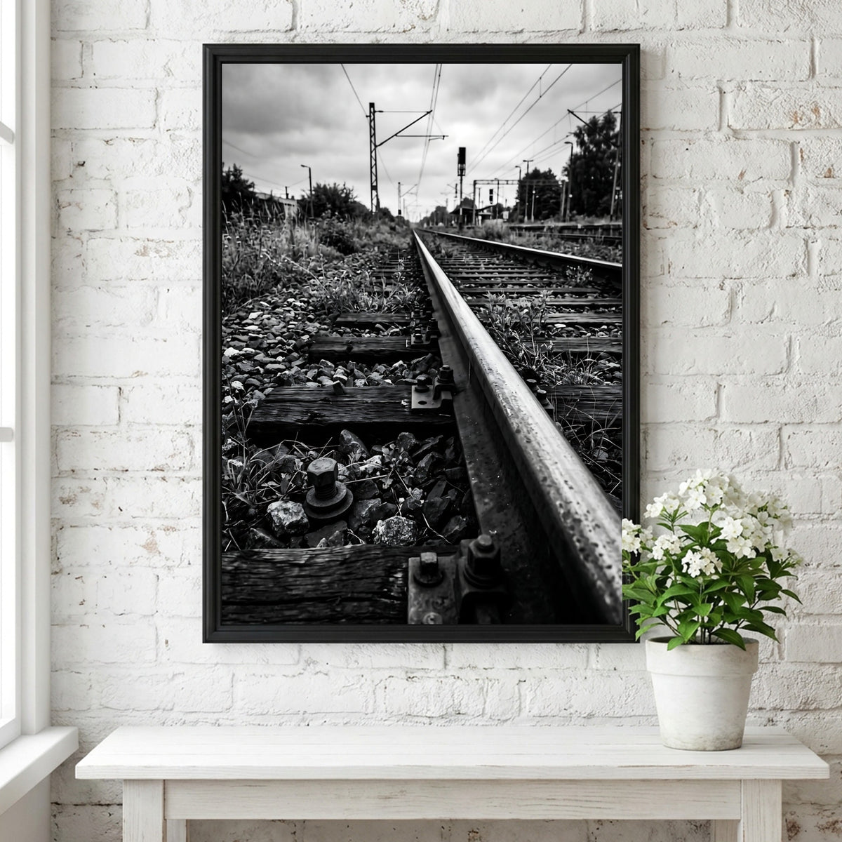 Black and white poster of railway tracks converging with wooden sleepers and overhead power lines