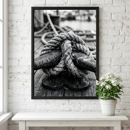 Nautical wall decor showing black and white close-up of rope tied around weathered deck cleat on wooden