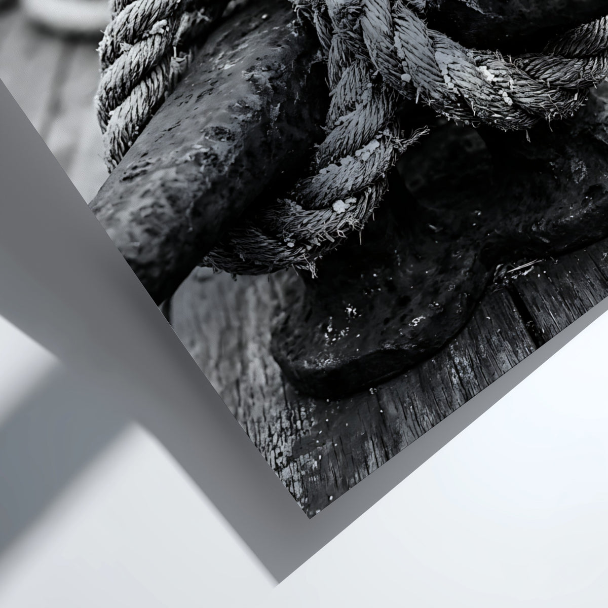 Nautical wall decor showing black and white close-up of rope tied around weathered deck cleat on wooden
