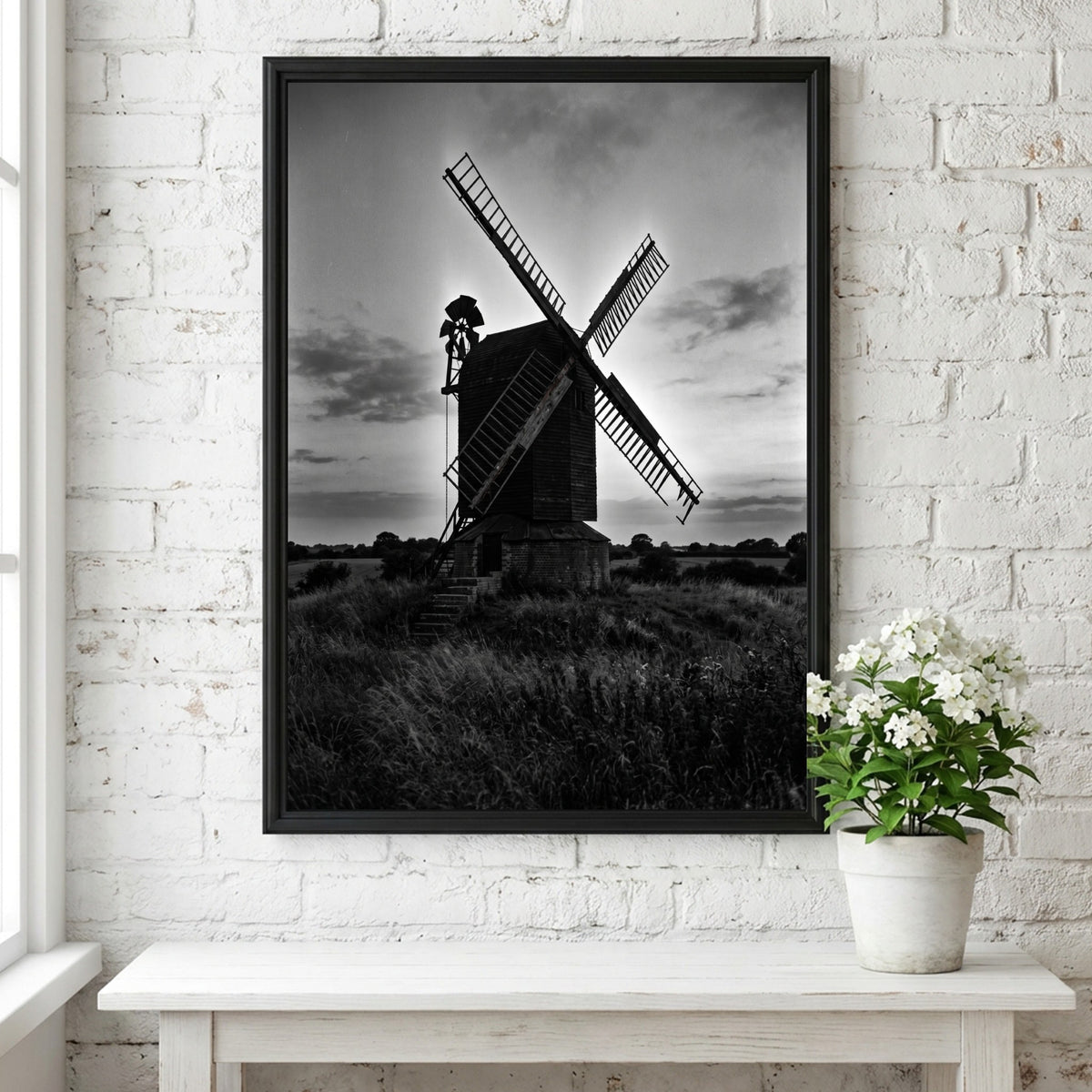 Black and white poster of rural windmill silhouette at dusk with moody sky and tall grass