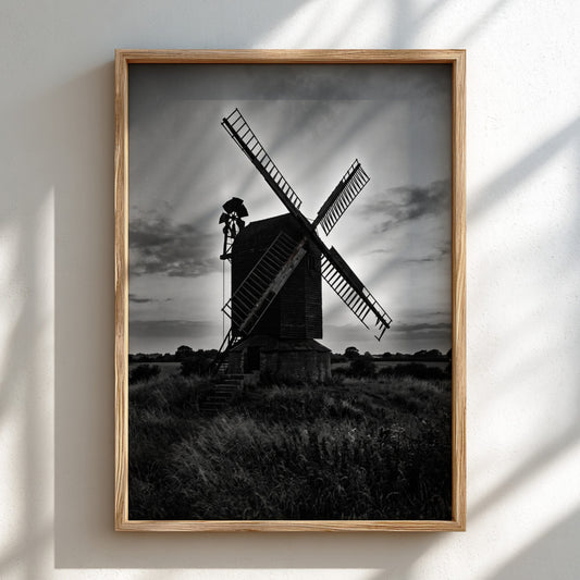 Black and white poster of rural windmill silhouette at dusk with moody sky and tall grass