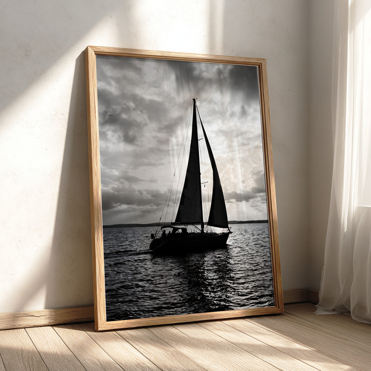 Black and white photographic wall decor featuring sailboat silhouette on water under bright cloudy sky