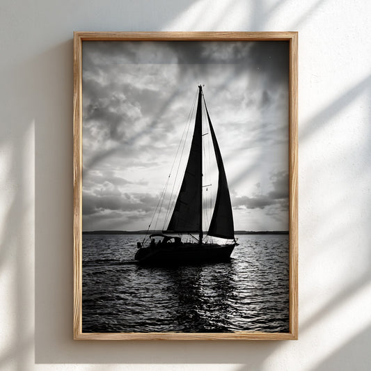 Black and white photographic wall decor featuring sailboat silhouette on water under bright cloudy sky