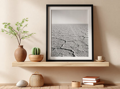 black and white wall decor of salt flat with cracked ground stretching to horizon in minimalist style