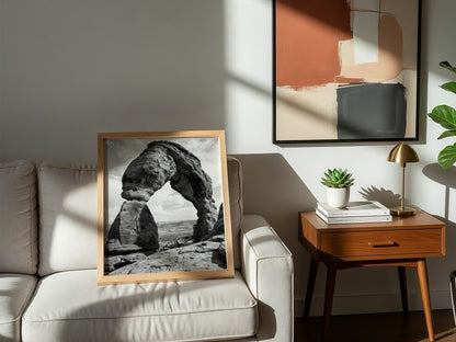 Black and white wall decor of sandstone arch in desert with textured rock and cloudy sky