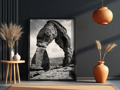 Black and white wall decor of sandstone arch in desert with textured rock and cloudy sky
