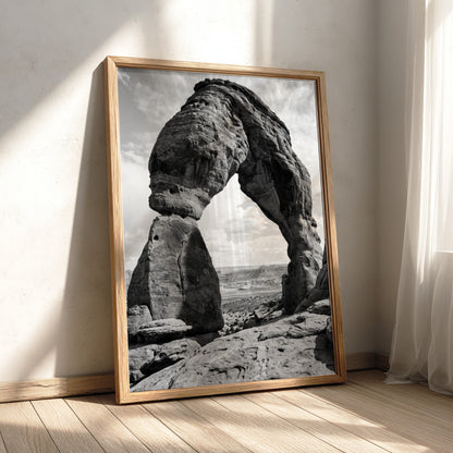 Black and white wall decor of sandstone arch in desert with textured rock and cloudy sky