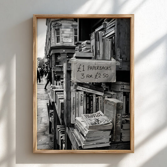 Black and white poster of secondhand bookstall with paperbacks and handwritten price sign