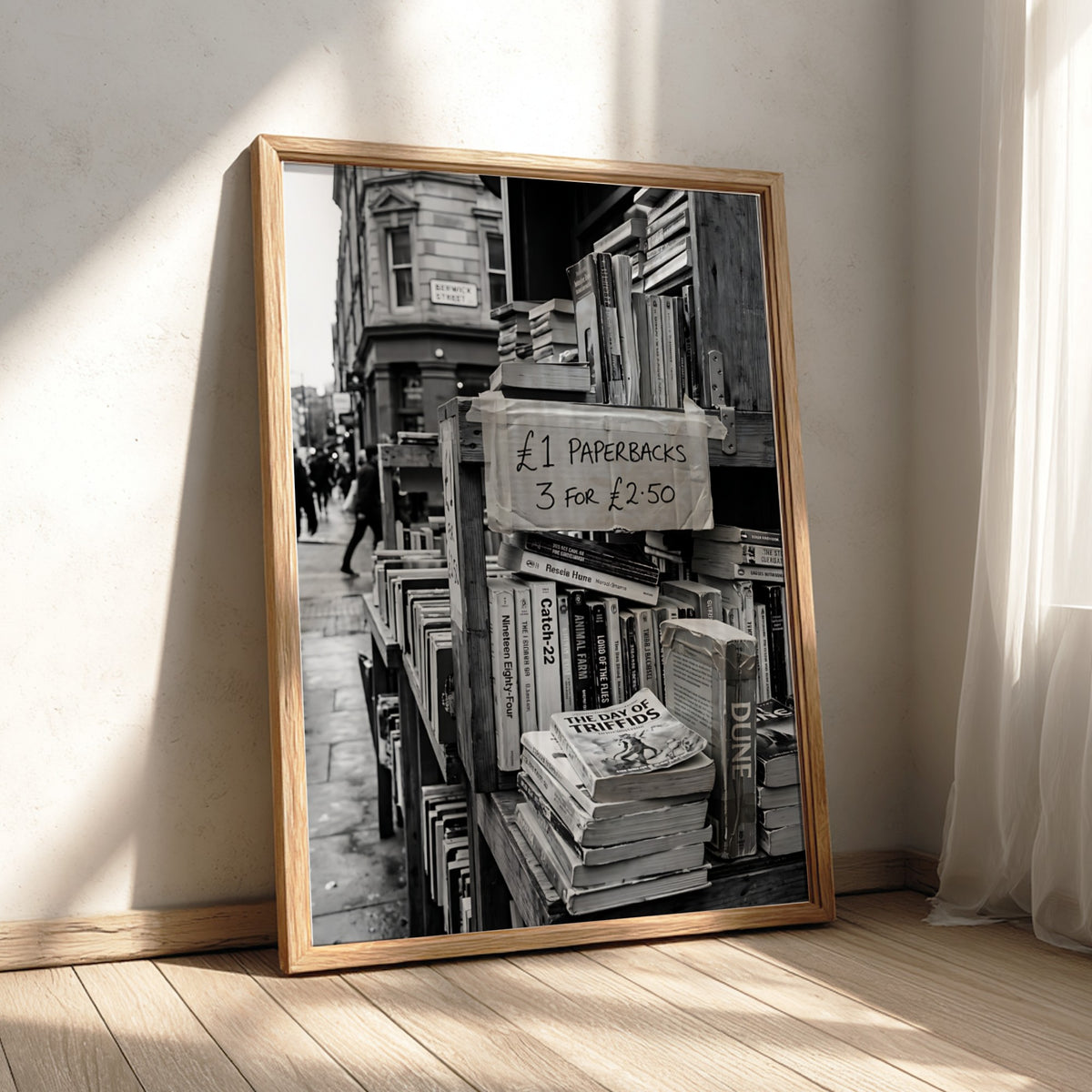 Black and white poster of secondhand bookstall with paperbacks and handwritten price sign