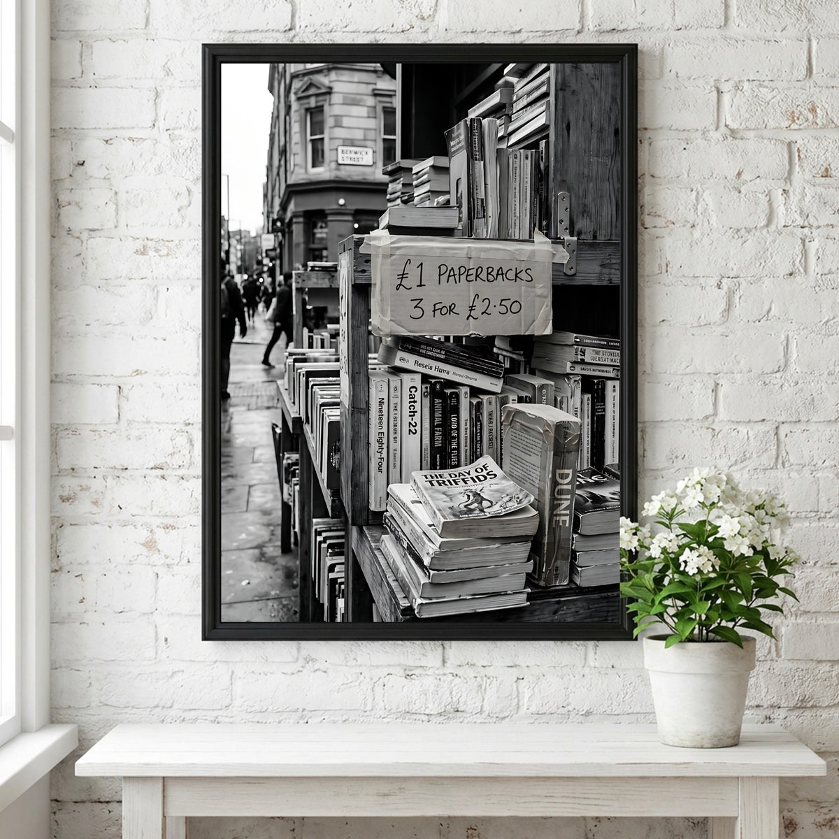 Black and white poster of secondhand bookstall with paperbacks and handwritten price sign
