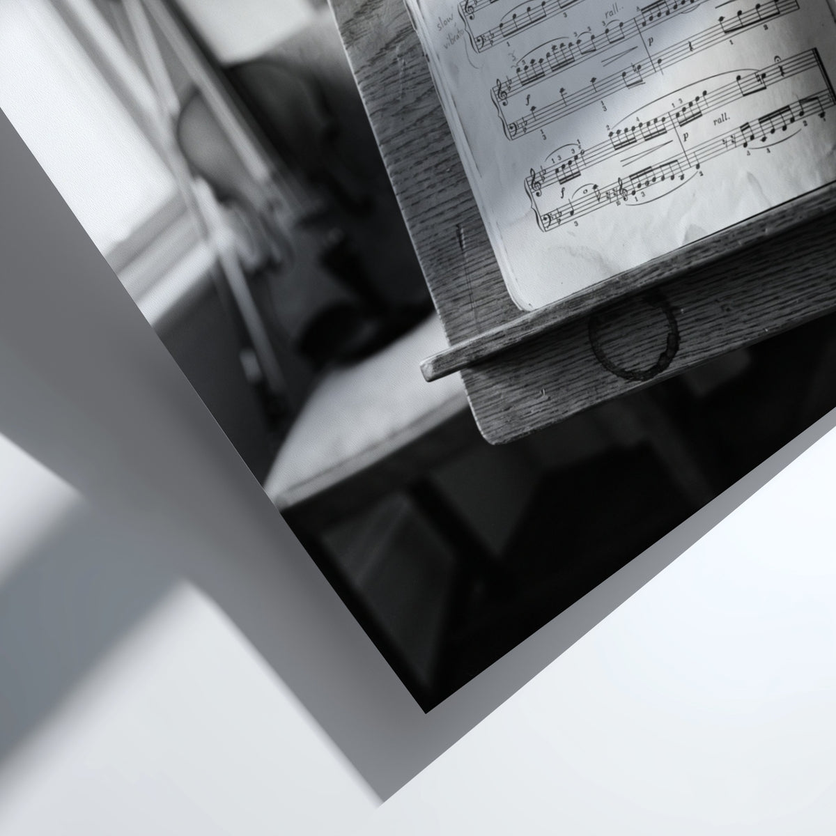 Black and white poster of sheet music on wooden stand with blurred violin in background