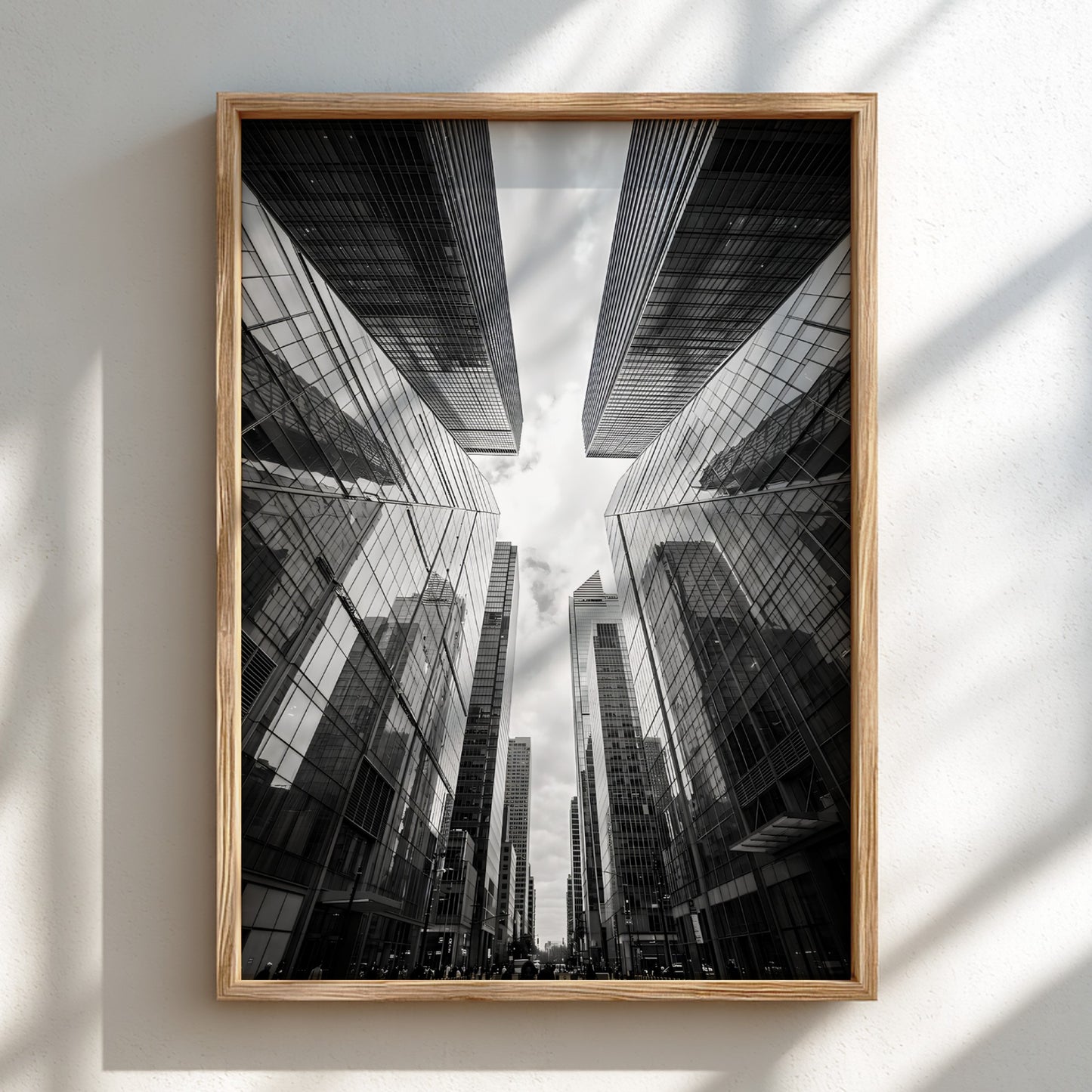 Wall decor featuring black-and-white urban photography of skyscrapers converging with reflective glass
