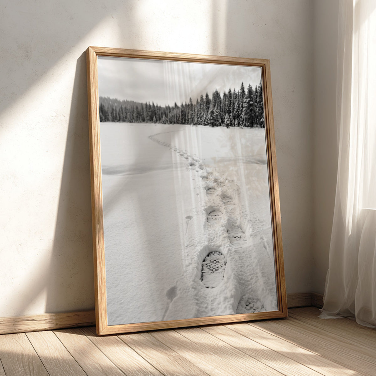 Photographic wall decor showing snowshoe tracks crossing a snowy white field with evergreen trees in