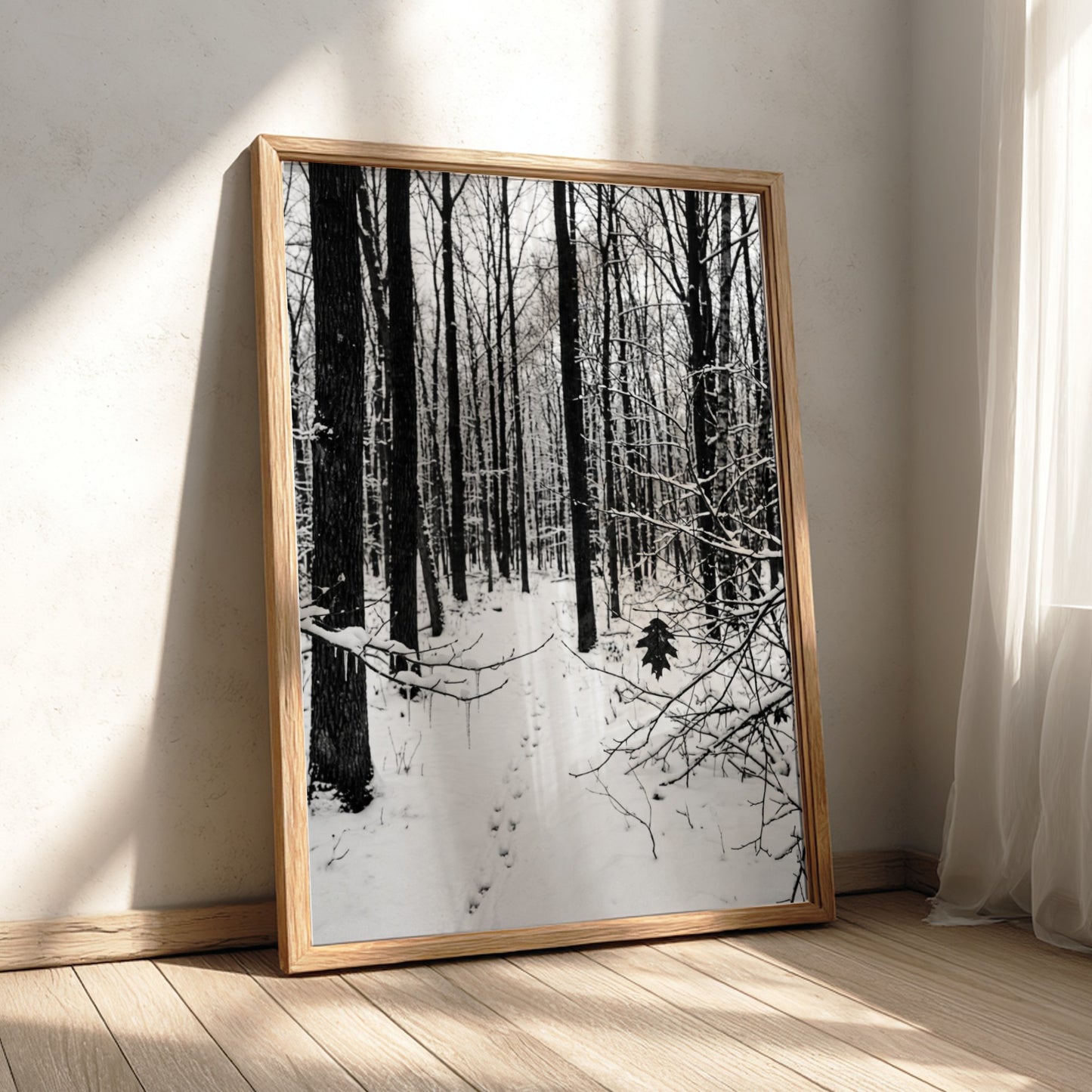 Framed wall decor showing a snowy forest winter landscape with tall bare trees and fresh white snow
