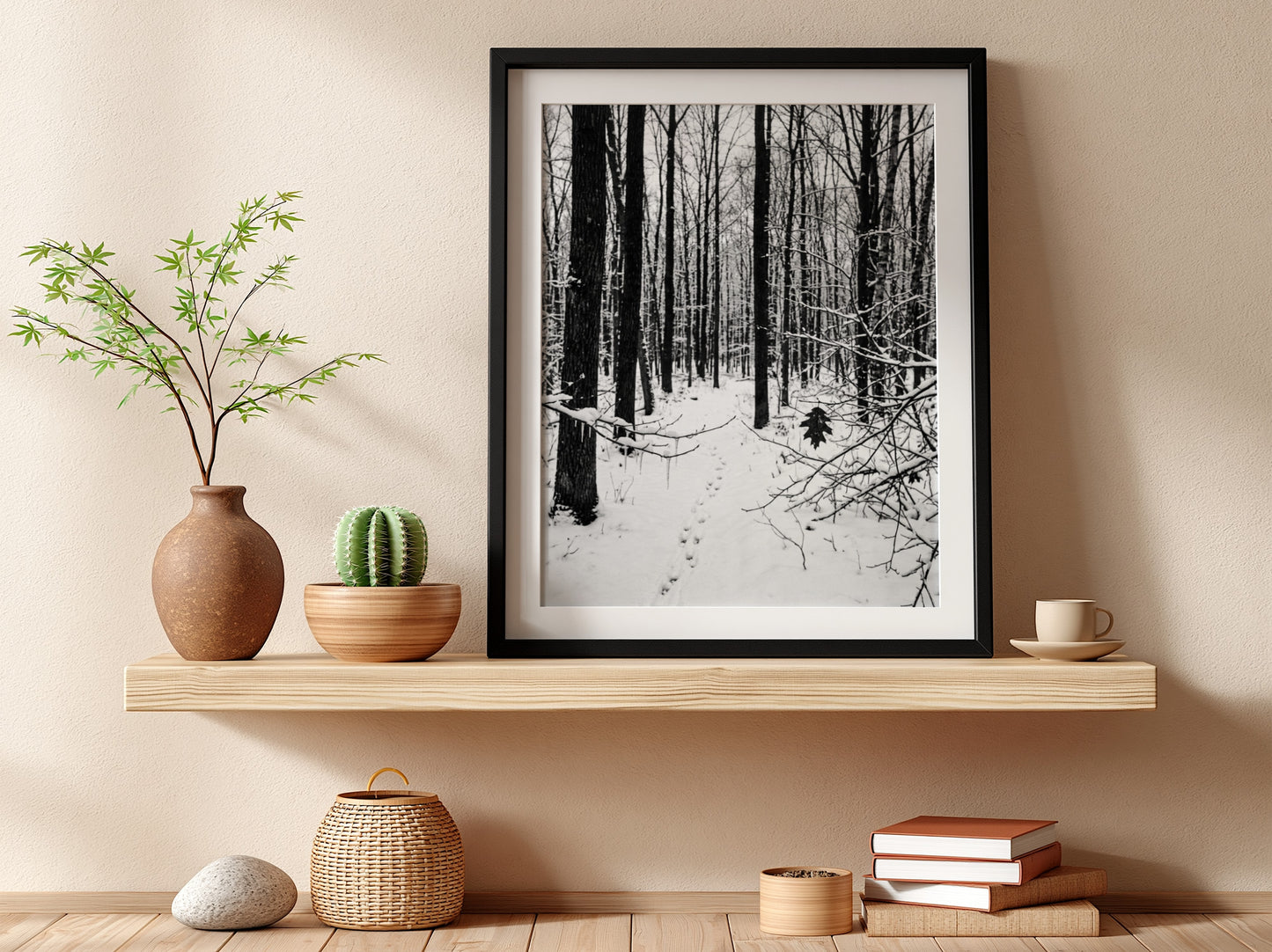 Framed wall decor showing a snowy forest winter landscape with tall bare trees and fresh white snow