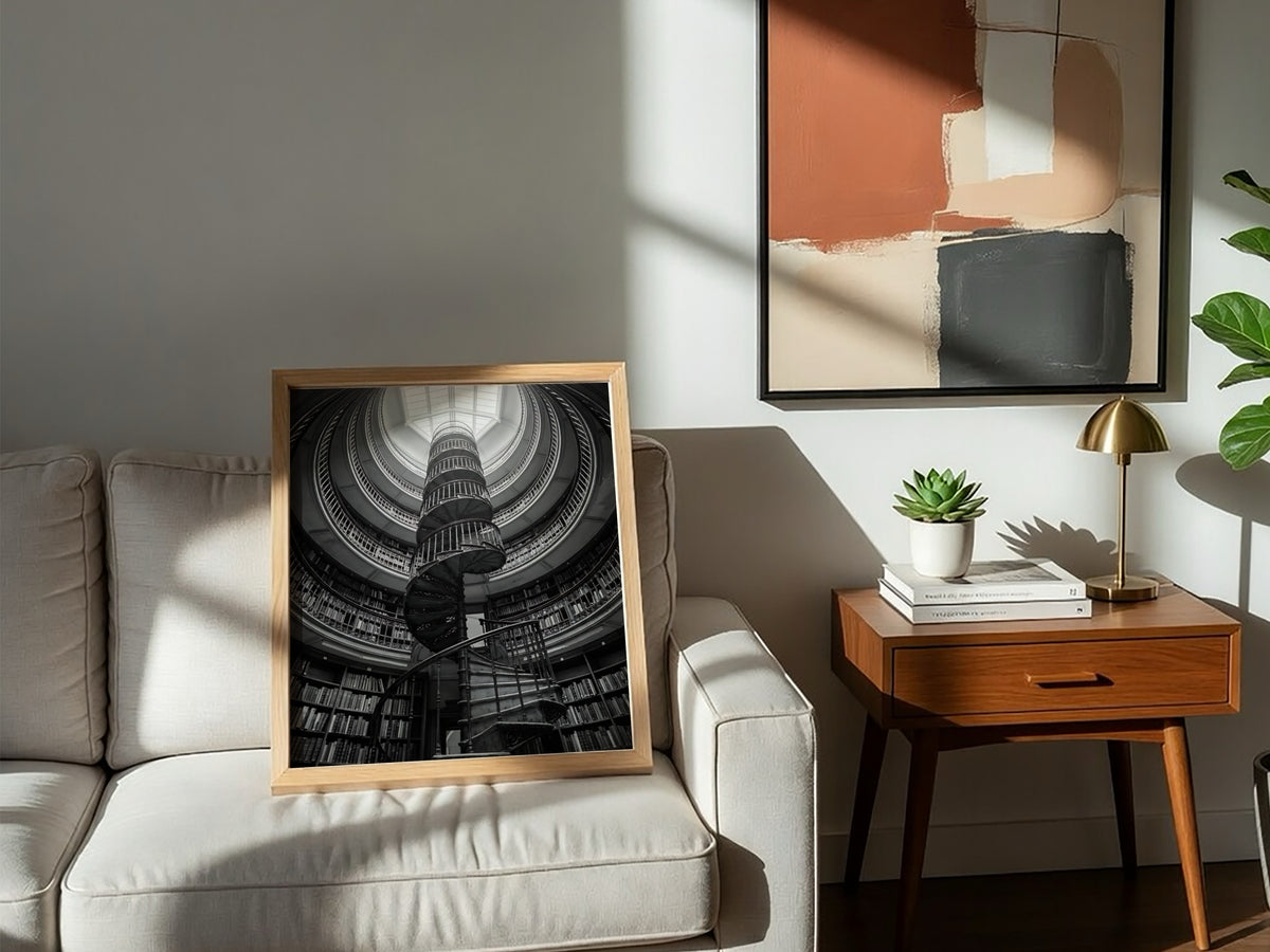 black and white poster featuring spiral staircase inside circular library with iron railings and skylight