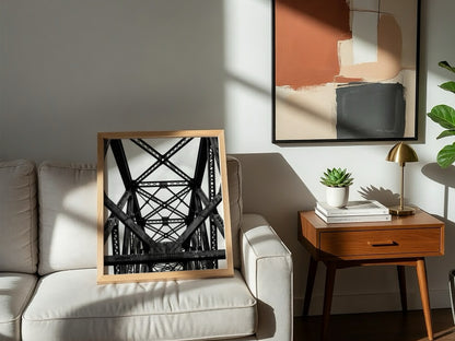Black and white wall decor featuring steel bridge trusses with geometric patterns and strong shadows