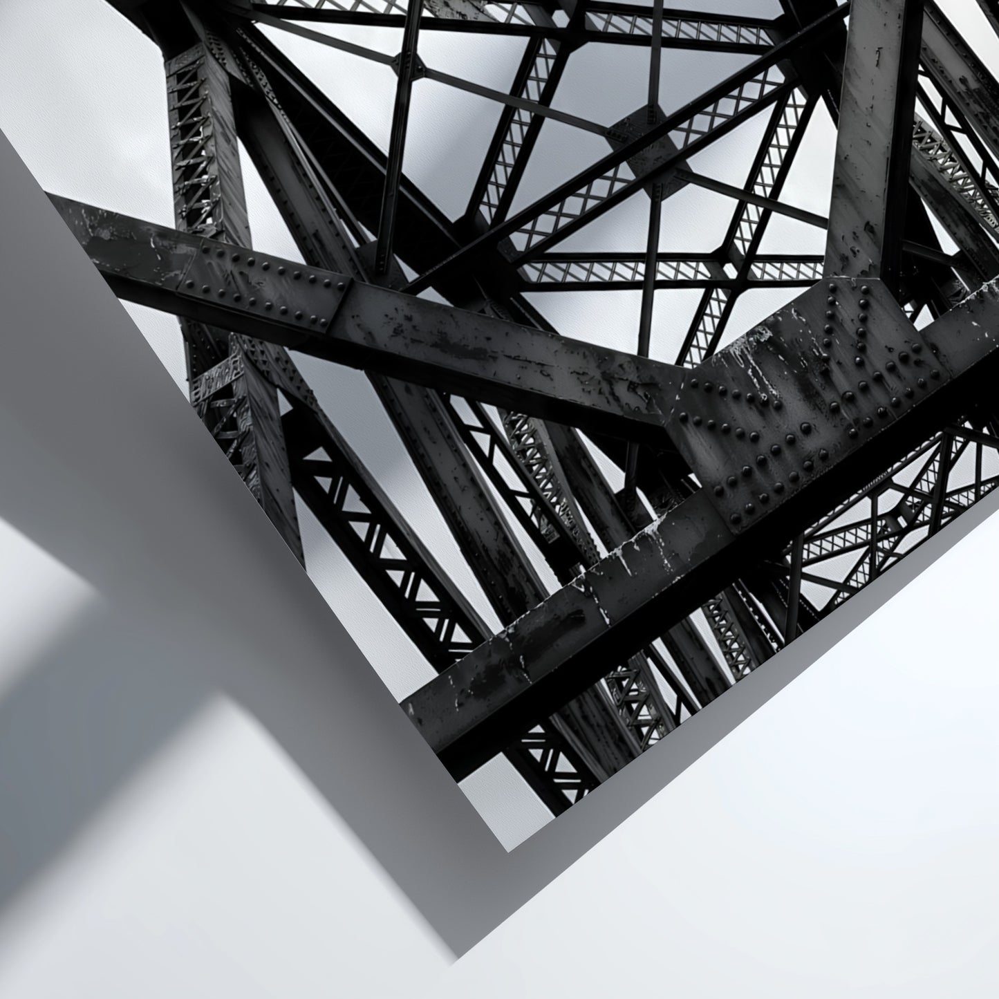 Black and white wall decor featuring steel bridge trusses with geometric patterns and strong shadows