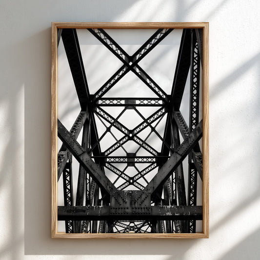 Black and white wall decor featuring steel bridge trusses with geometric patterns and strong shadows