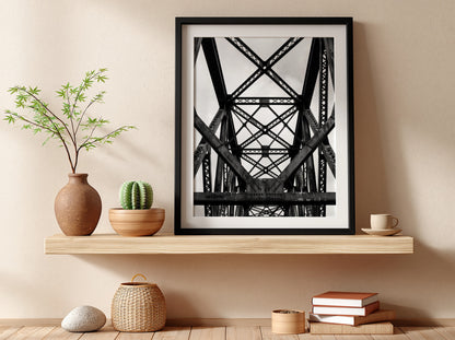 Black and white wall decor featuring steel bridge trusses with geometric patterns and strong shadows