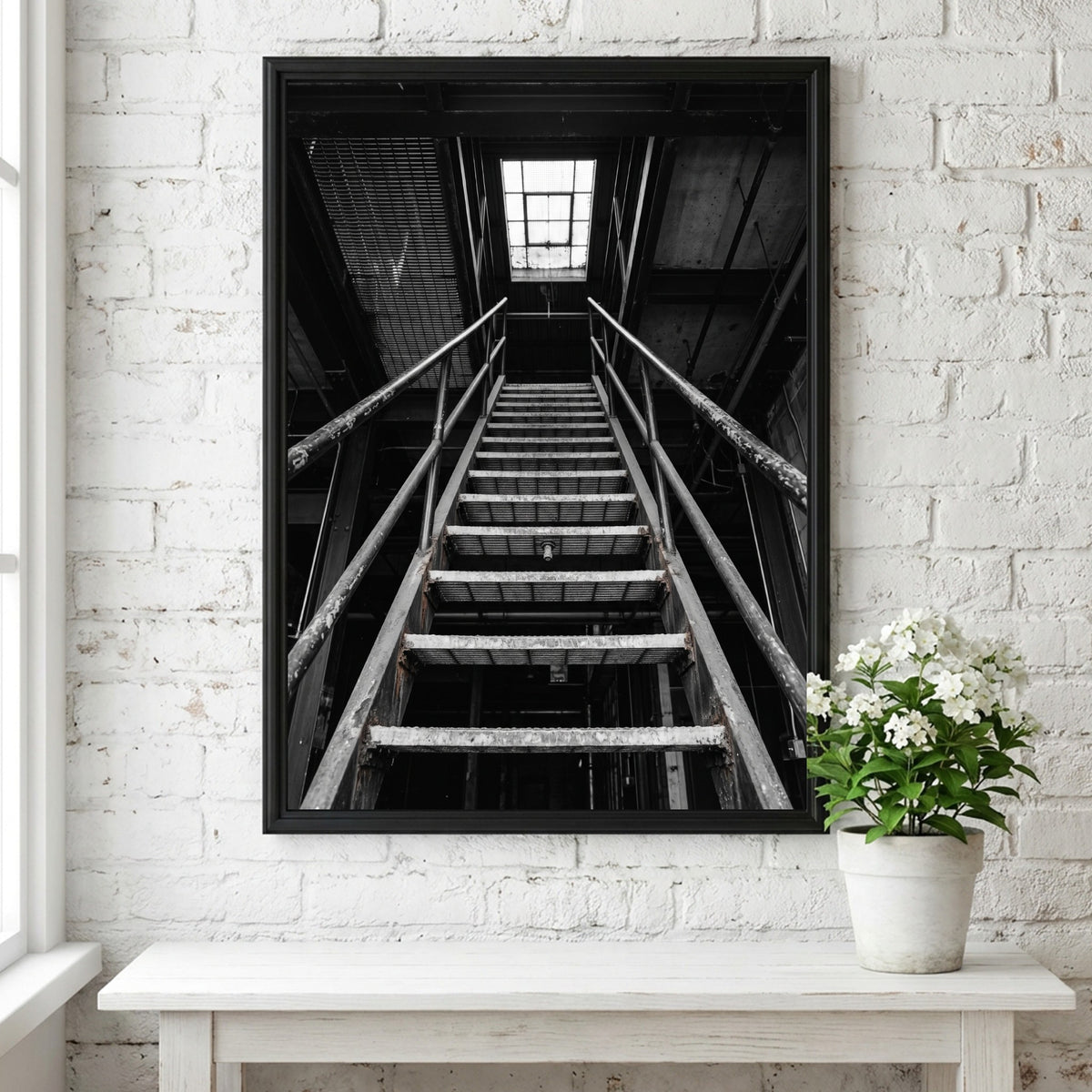 Black and white poster of steel staircase in industrial building with geometric lines and skylight