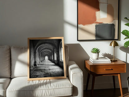 Black and white wall decor of stone corridor with rounded arches and textured stone floor