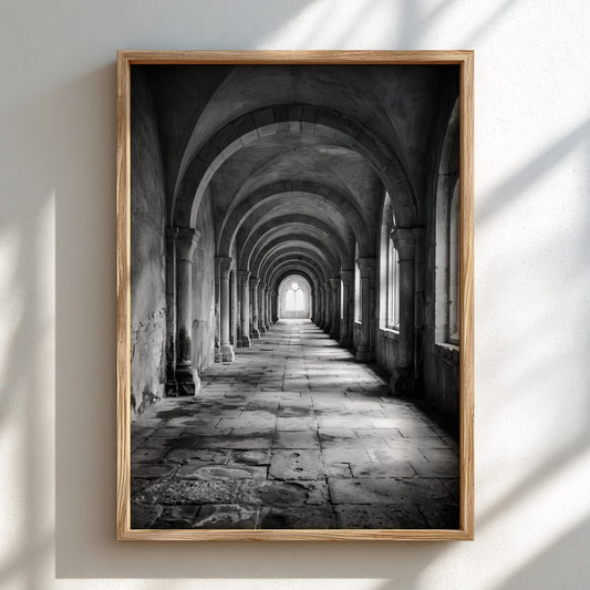 Black and white wall decor of stone corridor with rounded arches and textured stone floor