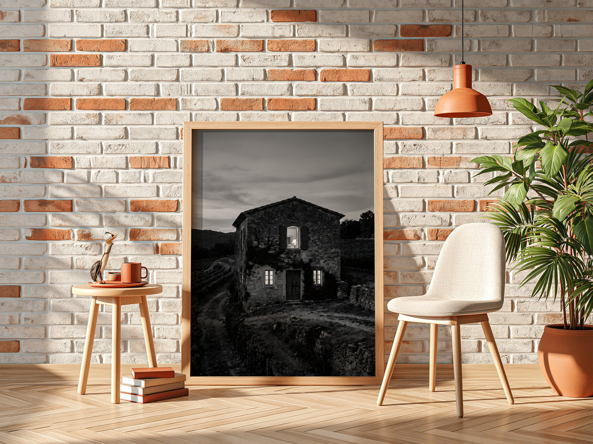 Black and white wall decor featuring a stone vineyard estate house at dusk with shutters and winding path