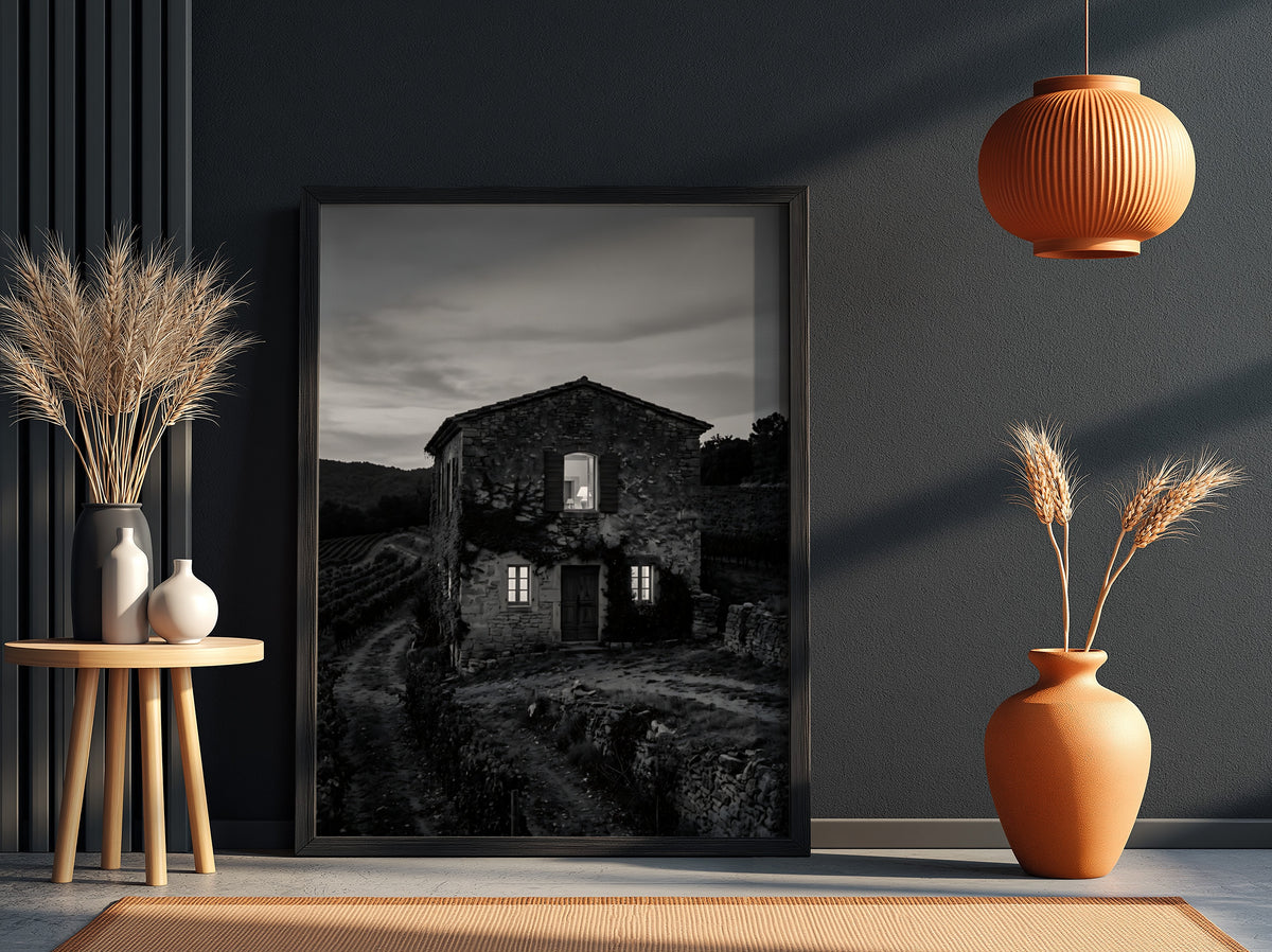 Black and white wall decor featuring a stone vineyard estate house at dusk with shutters and winding path