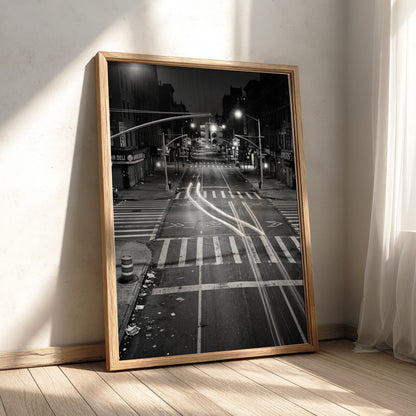 black and white wall decor of taxi passing empty city intersection with light trails at night