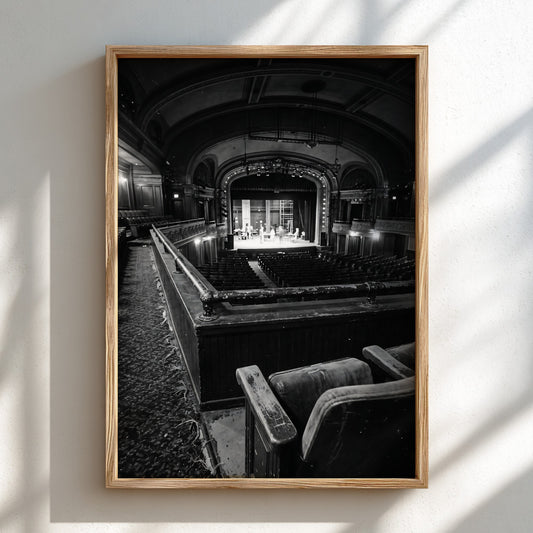Black and white poster showing vintage theater balcony view with seats and stage
