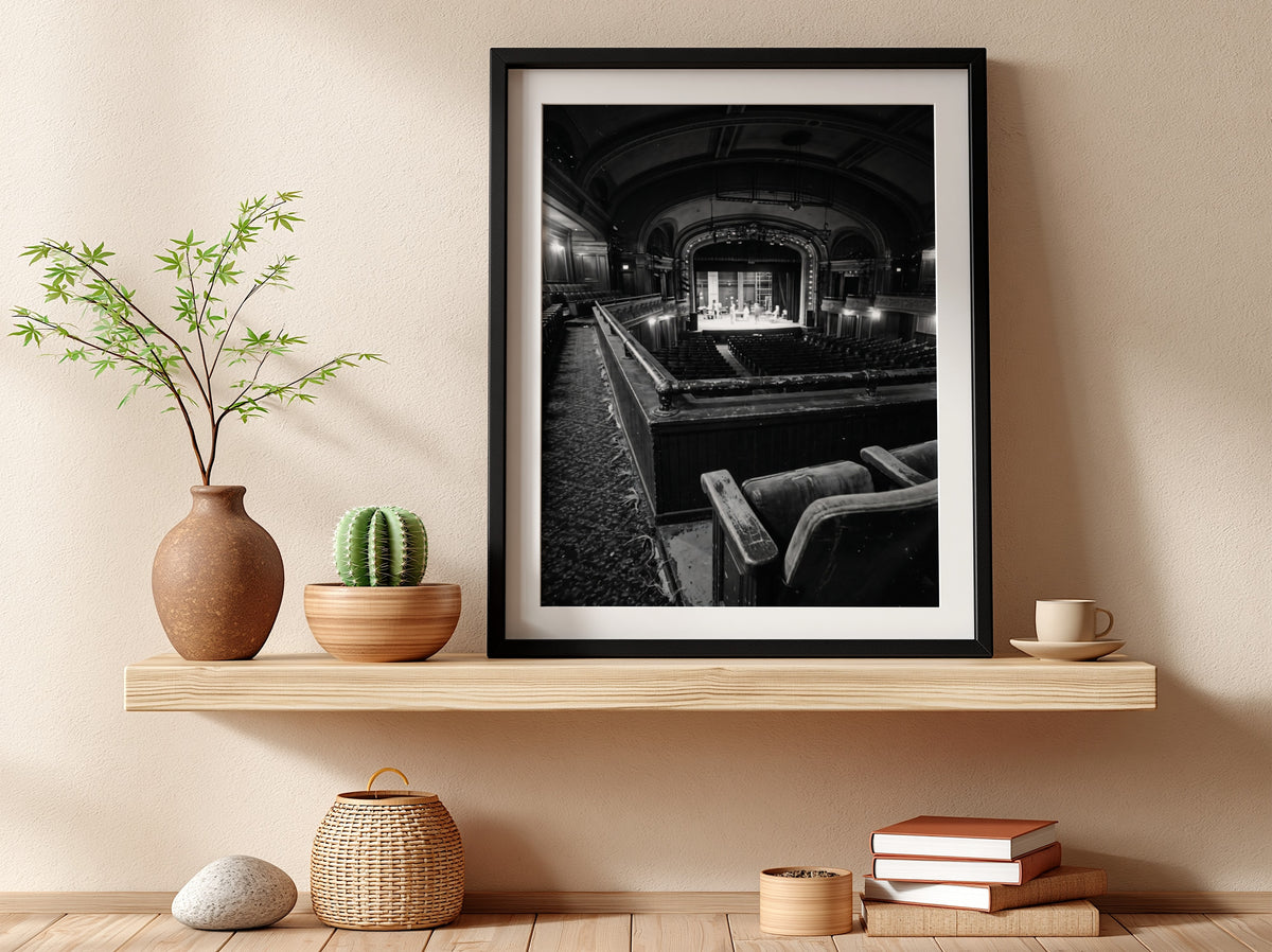 Black and white poster showing vintage theater balcony view with seats and stage