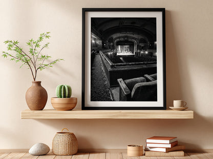 Black and white poster showing vintage theater balcony view with seats and stage