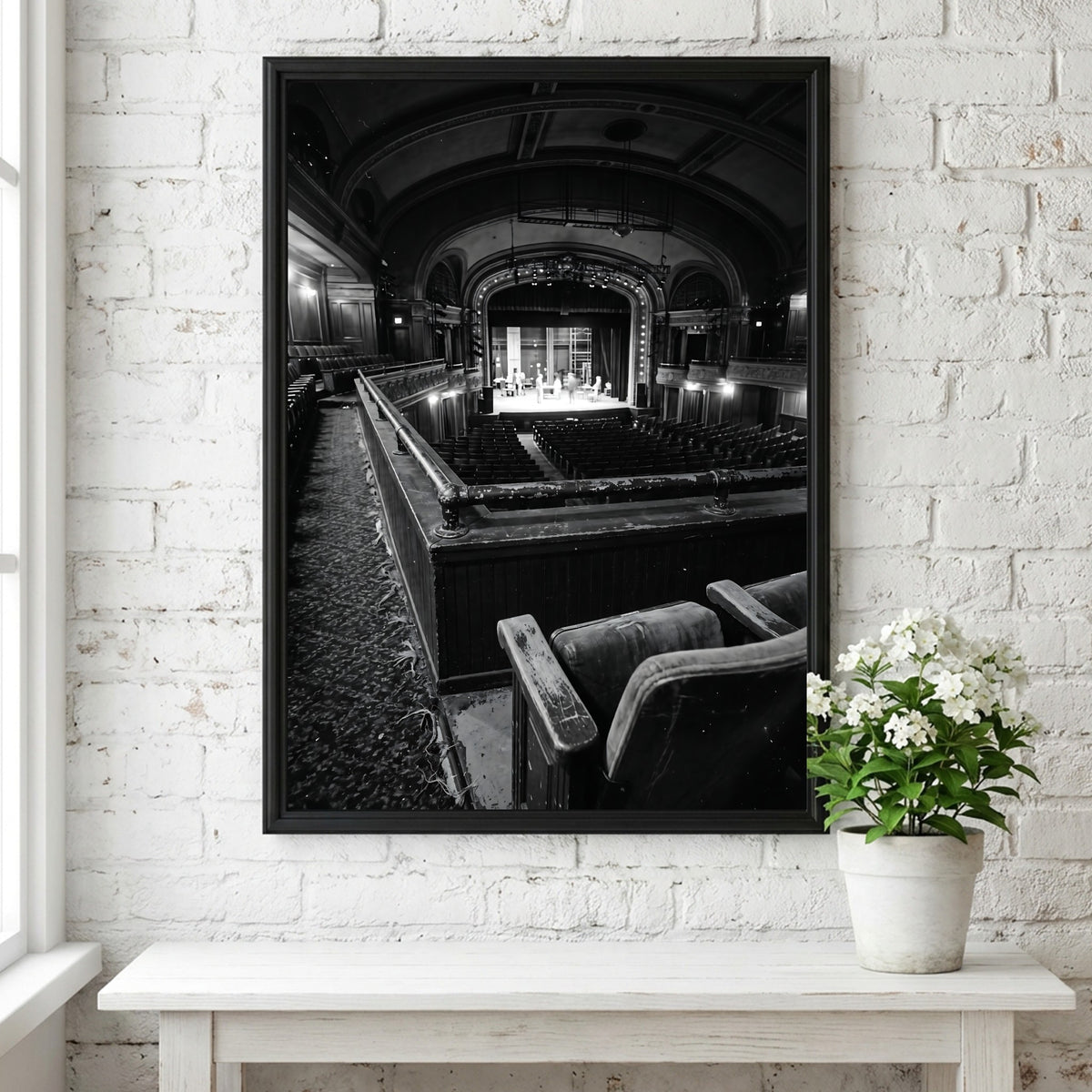 Black and white poster showing vintage theater balcony view with seats and stage