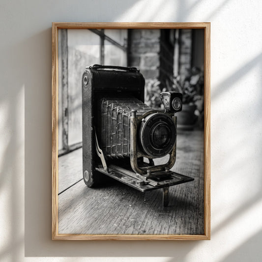 Vintage folding camera wall decor in black and white with wooden table and soft background