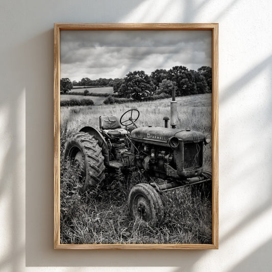 Vintage tractor poster in black and white showing rustic tractor parked in grassy field with trees and cloudy