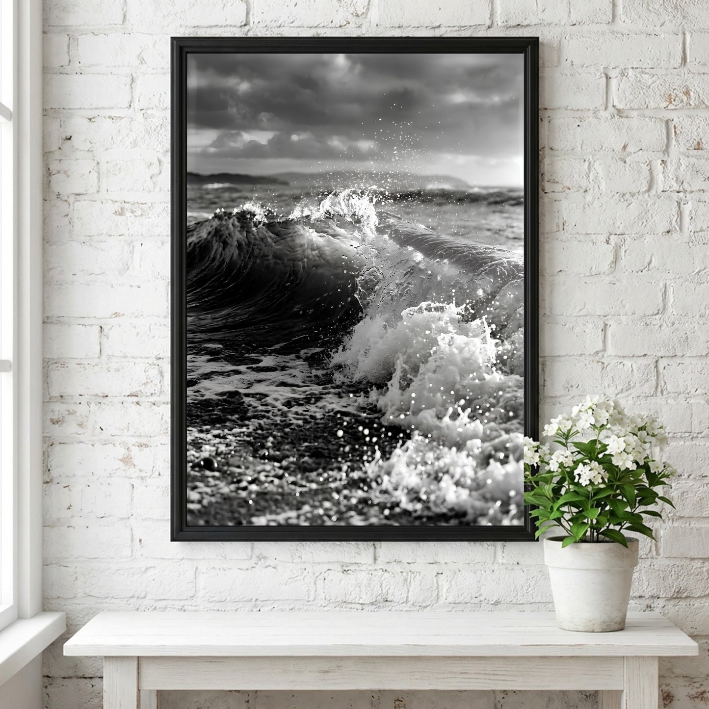 Black and white poster of a breaking wave on rocky beach with splashing water and moody sky