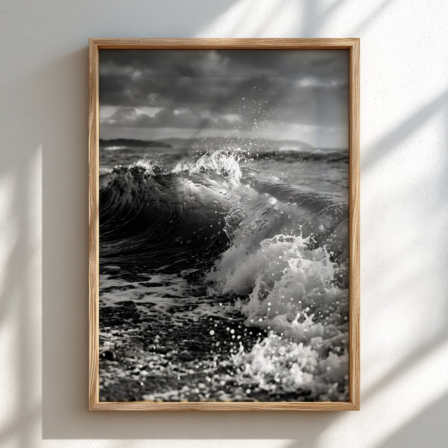 Black and white poster of a breaking wave on rocky beach with splashing water and moody sky