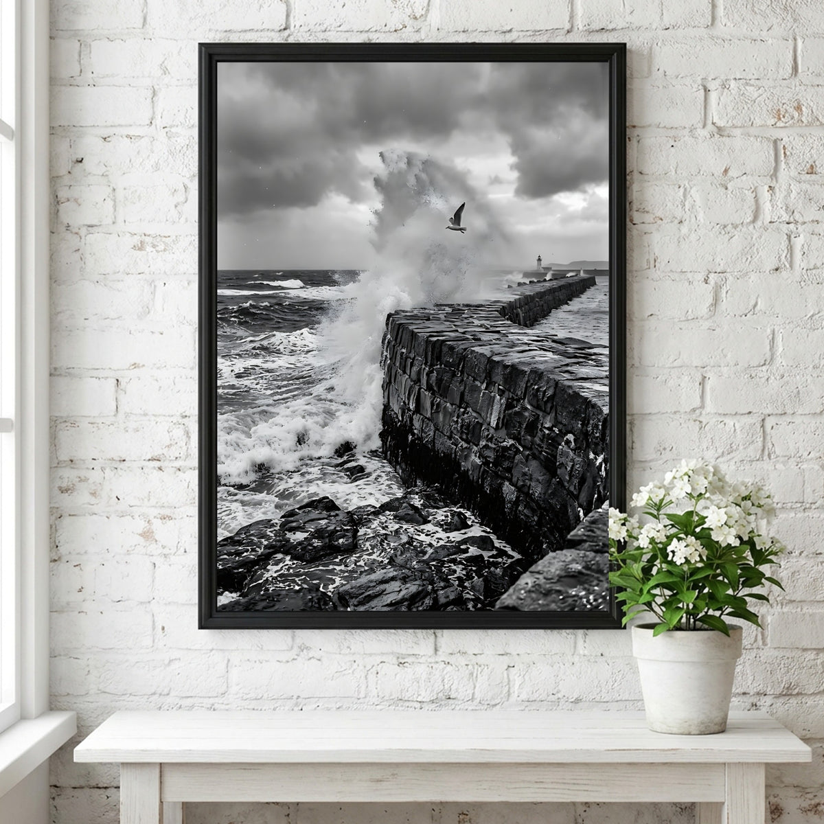 Black and white poster of waves crashing against rugged stone wall under cloudy sky with seagull flying