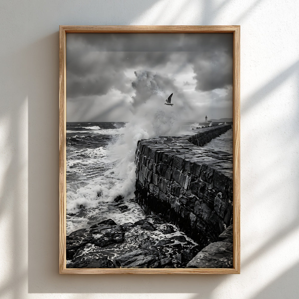 Black and white poster of waves crashing against rugged stone wall under cloudy sky with seagull flying
