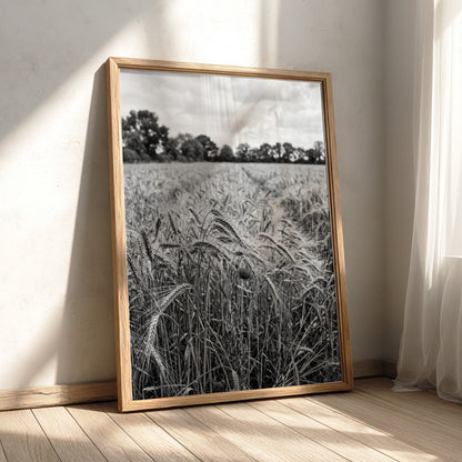 Black and white poster of wheat field with tall stalks swaying and trees in background