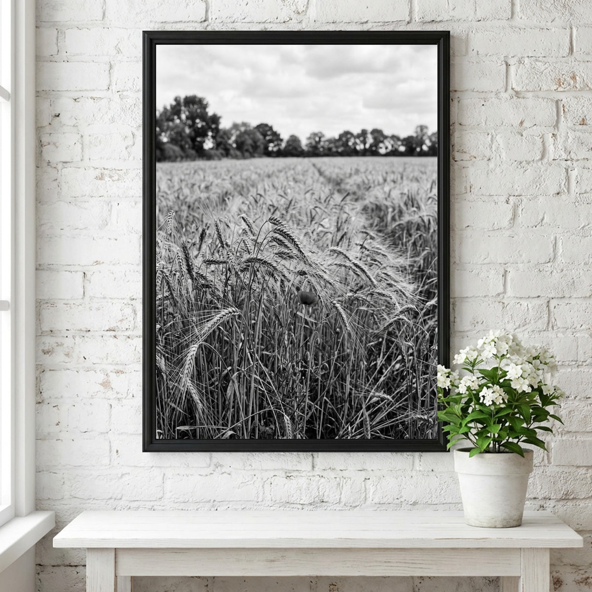 Black and white poster of wheat field with tall stalks swaying and trees in background