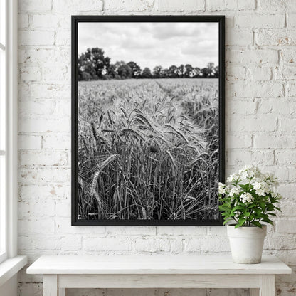 Black and white poster of wheat field with tall stalks swaying and trees in background
